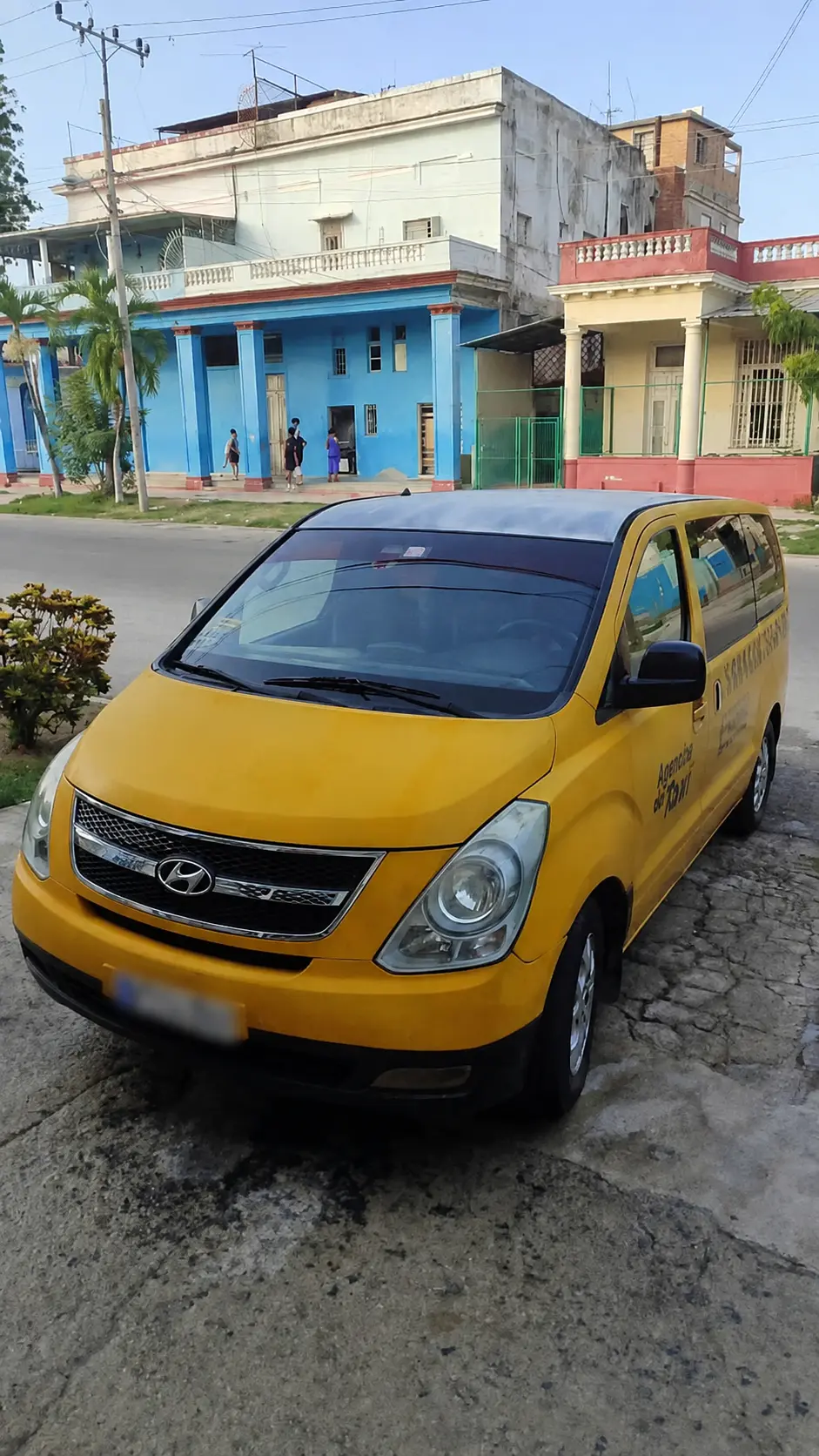 Vehículo amarillo de pasajeros estacionado en una calle de La Habana.